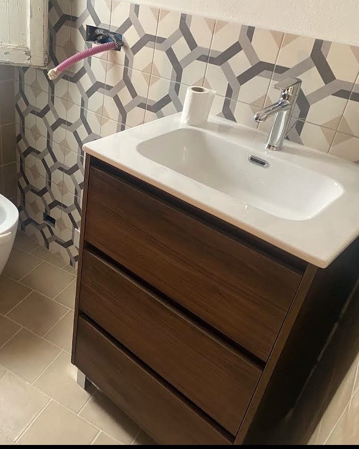 Mobile bagno in legno scuro con lavabo e sanitari sospesi