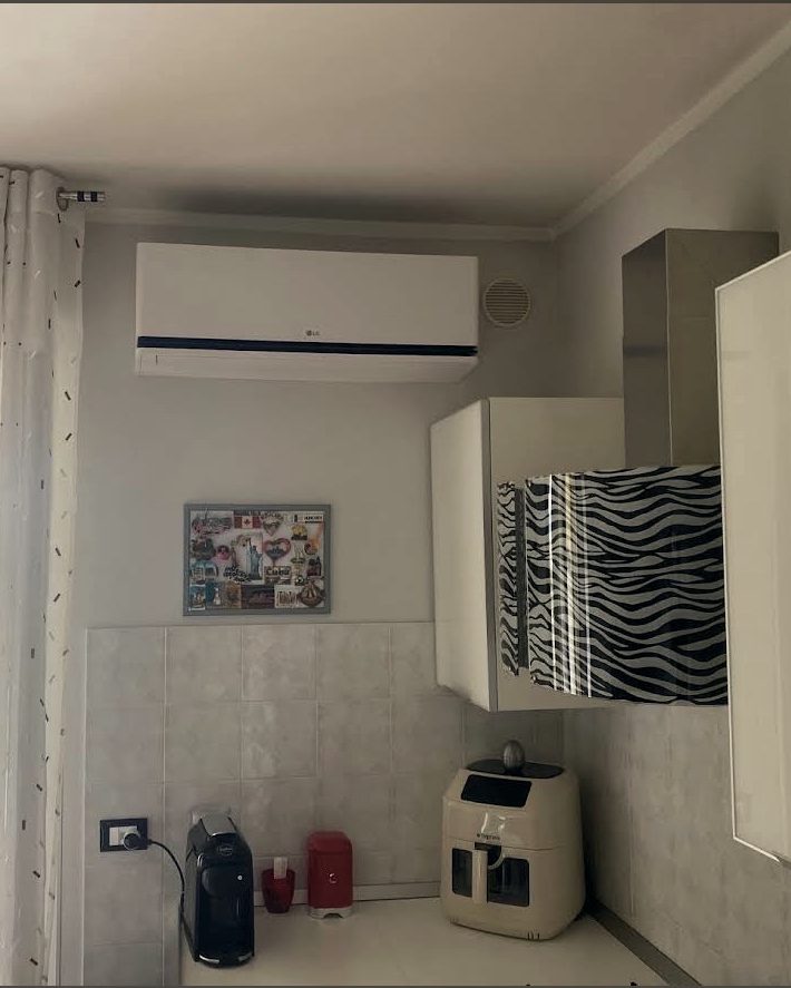 Climatizzatore installato sopra la portafinestra di una cucina