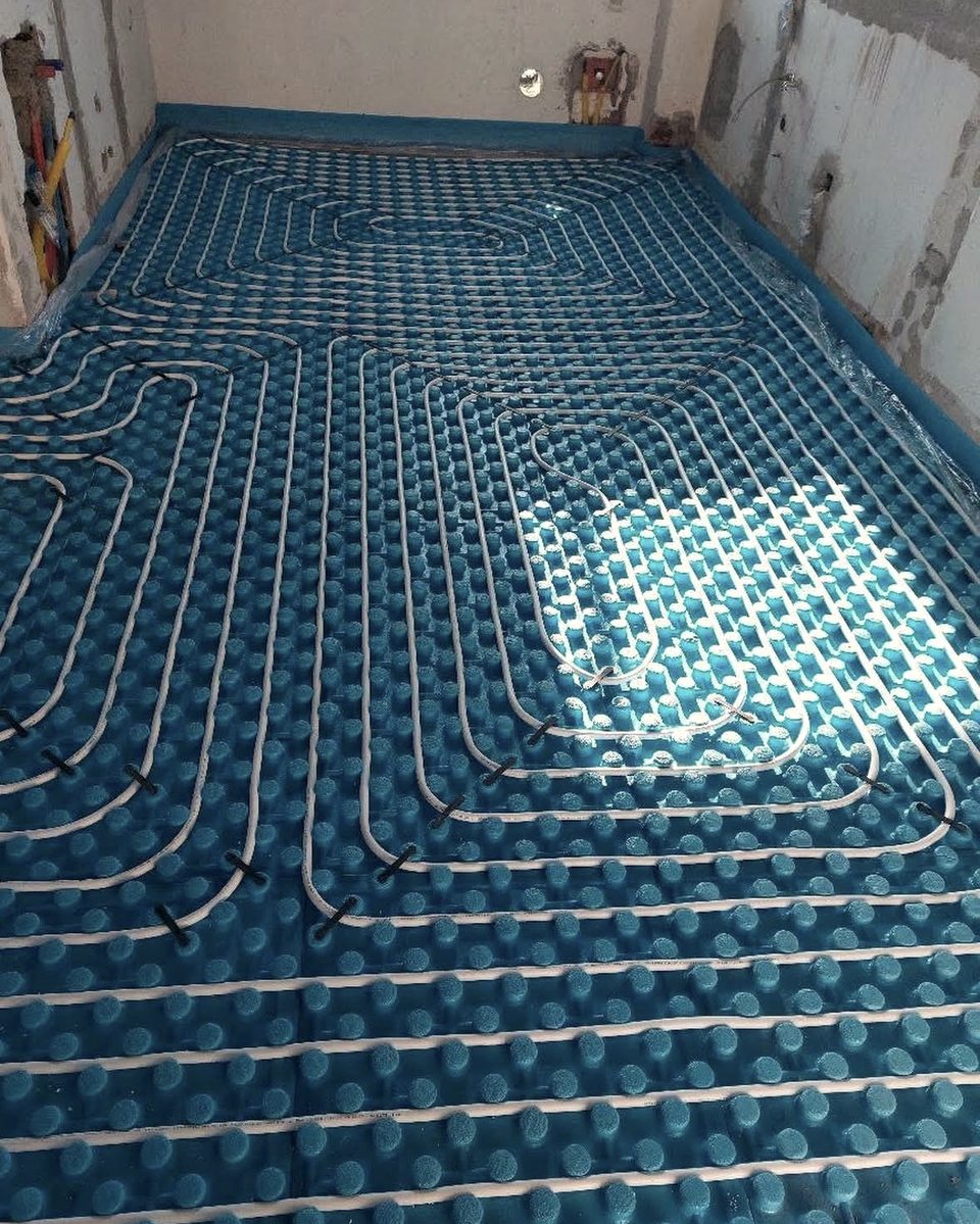 Riscaldamento a pavimento con i tubi posati sui pannelli blu